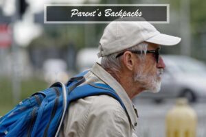 An older man wearing sunglasses and carrying a backpack for parents