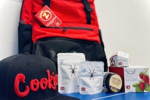 Display of a cookies backpack, hat, coffee bag, and honey jar for sale.